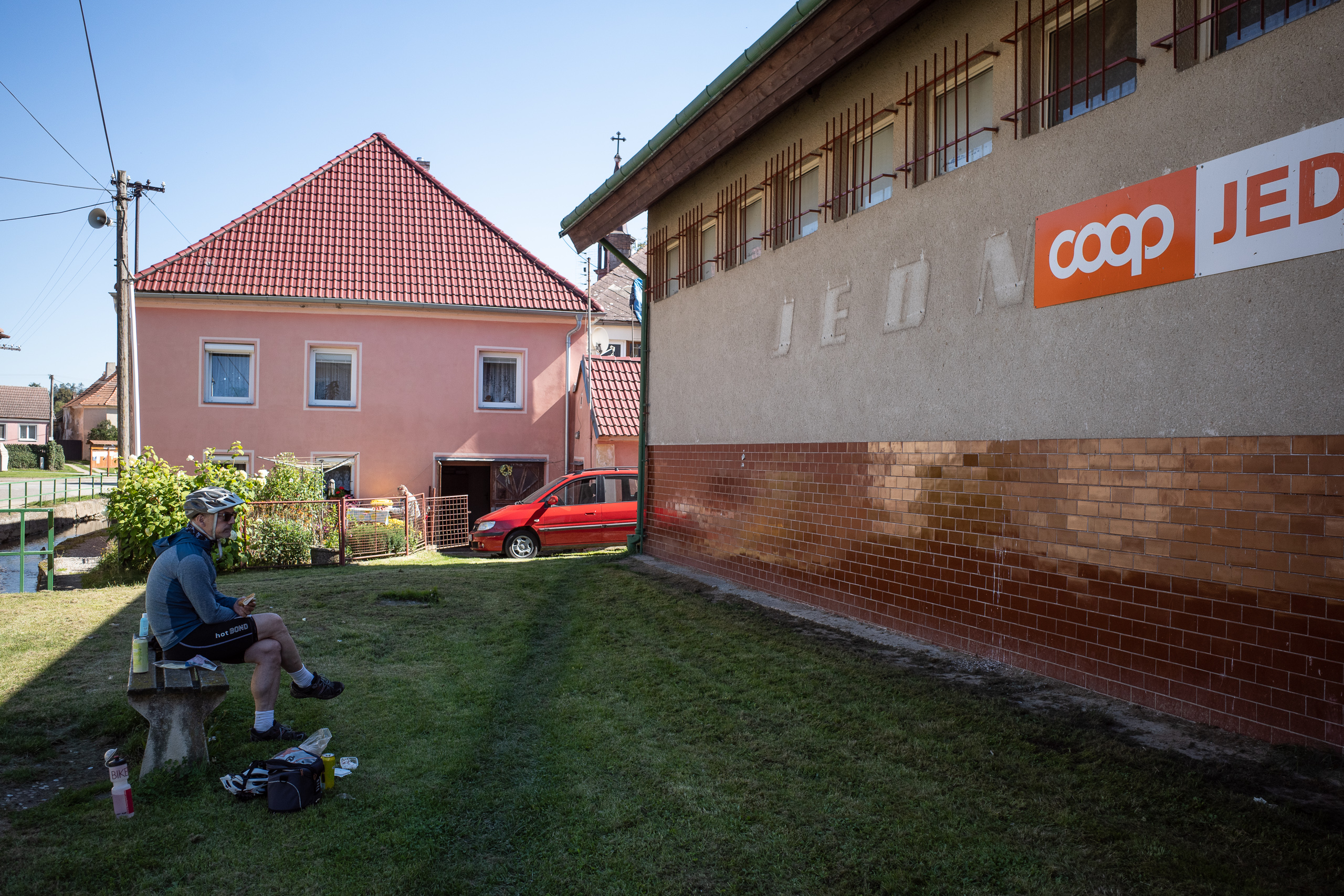 Jause im Schatten des coop in Písečné – darunter noch der JEDNOTA-Schriftzug